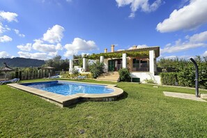 Ein Wohnhaus mit Schwimmbad, gepflegtem Rasen und einem Dach mit Ziegeldeckung.