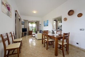 Geräumiges und helles Wohn- und Esszimmer mit Sitzbereich, Esstisch und Zugang zur Terrasse in der Villa Catalina, Ferienhaus in Alcudia, Mallorca.