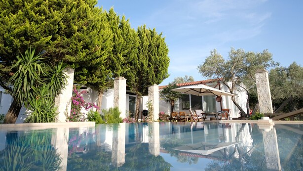 A pool with clear water, surrounded by greenery and a covered seating area. - Bir dem Urla (Urla)