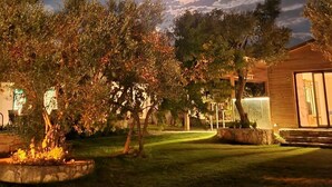 A nighttime view of a residential area with a house, trees, and a visible moon. - Bir dem Urla (Urla)