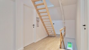 A modern interior with a wooden staircase leading to a skylight. - Vacation home Staedenbergh in rural Staden! 10 pers (Staden)