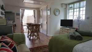 Ett hotellrum med en säng, en TV, ett skrivbord och en stol.