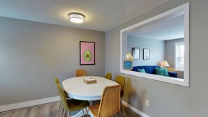 A dining area with a round table, chairs, and a ceiling light fixture. - 5 Min Walk to Beach and Pier (Old Orchard Beach)