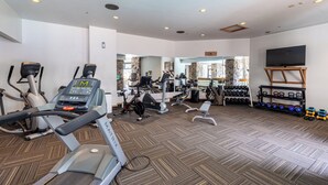 A gym with treadmills, elliptical machines, and weightlifting equipment. - Shoshone Ski-In/Out w/ amazing views, community hot tub/pool/fitness center & fireplace! (Big Sky)