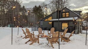 A house with a fire pit in the snow, surrounded by wooden chairs. - Acorn Bungalow & Lodge - Luxury Cabin, Catskills (Cairo)
