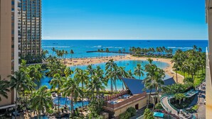 Un complexe hôtelier doté d’une grande piscine, de palmiers et d’une plage.