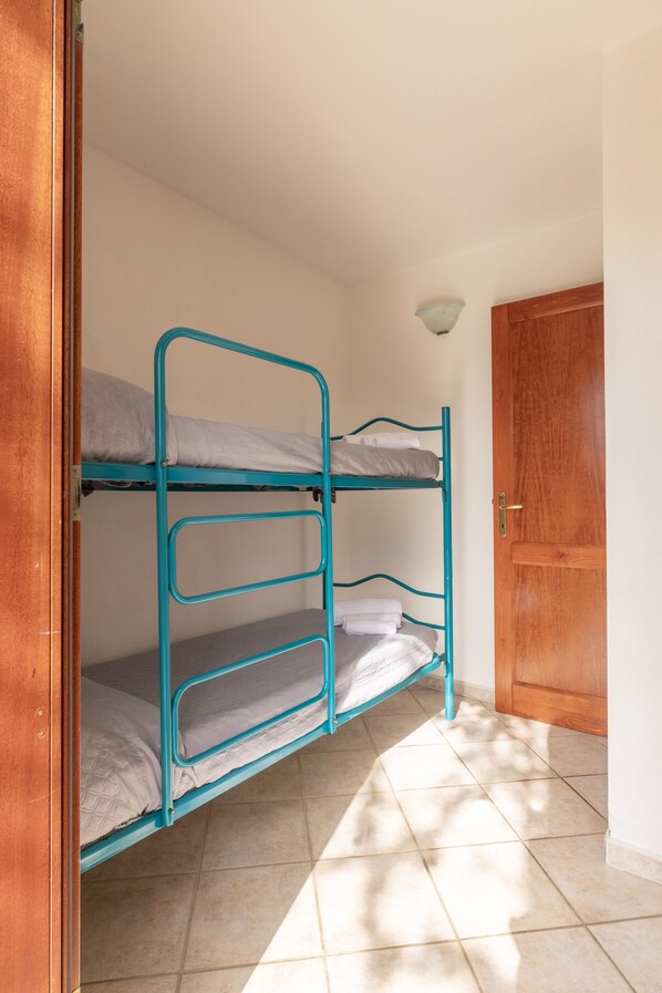 A bunk bed with a wooden door and a light fixture in the corner.