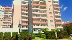 A multi-story residential building with balconies, satellite dishes, and a visible storefront. - Cosy Apartament in Rzeszów City Centre (Rzeszów)