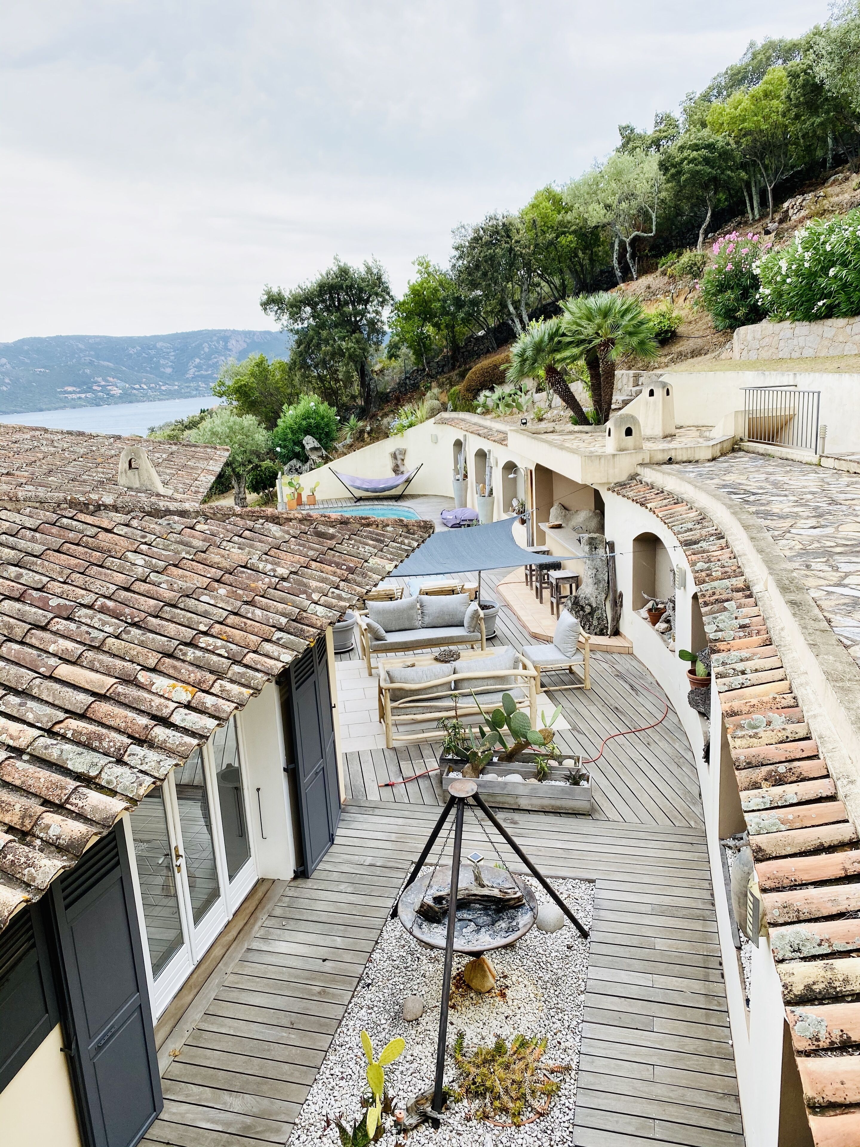 Une terrasse sur le toit avec une piscine, des espaces de détente et une vue sur la mer.