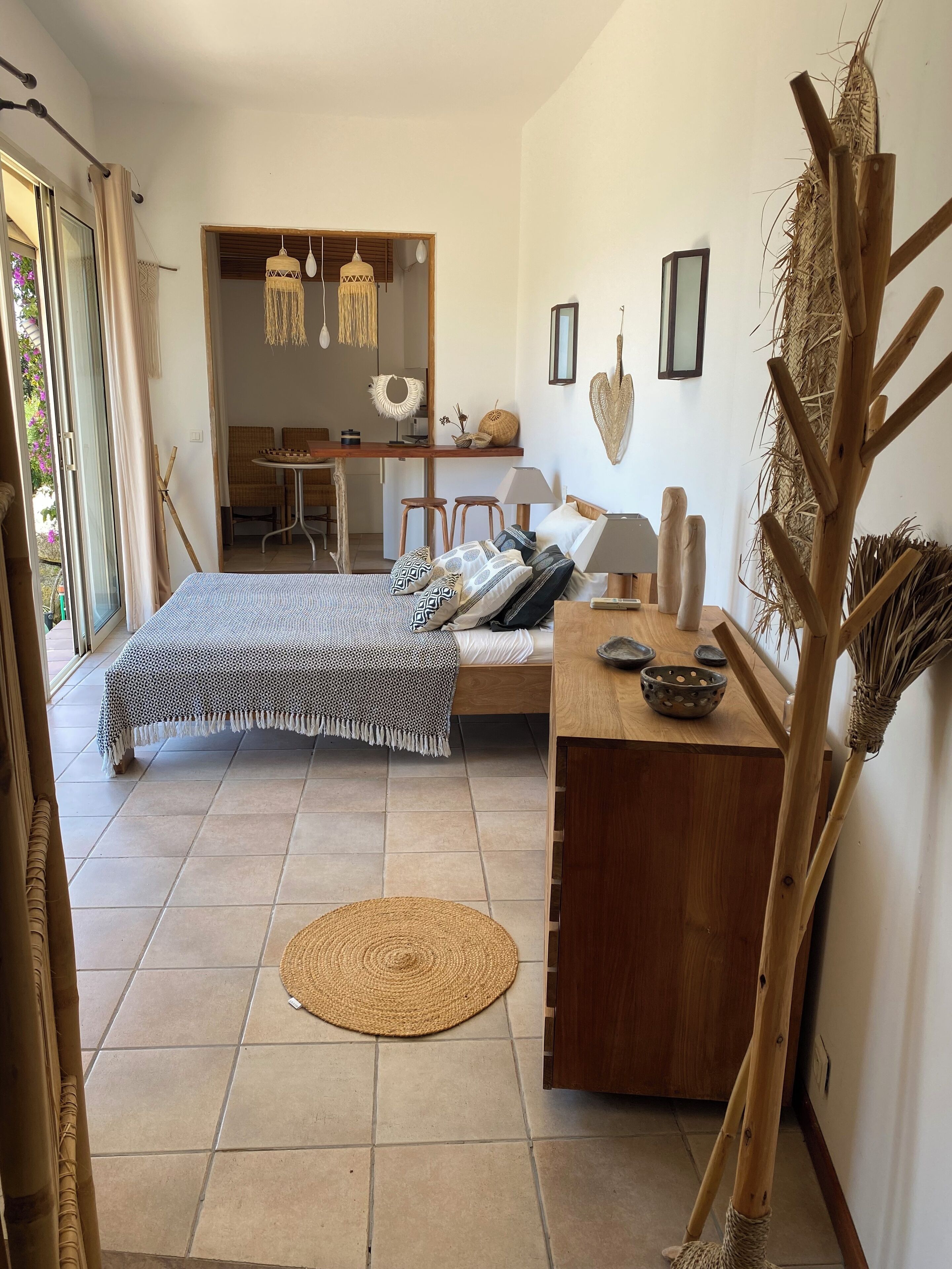 Une chambre à coucher avec un lit, une table de chevet et une vue sur la salle à manger.