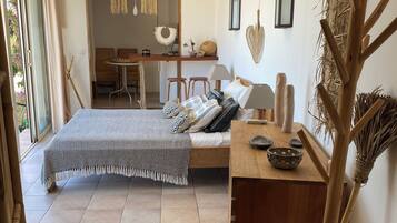 Une chambre à coucher avec un lit, une table de chevet et une vue sur la salle à manger.