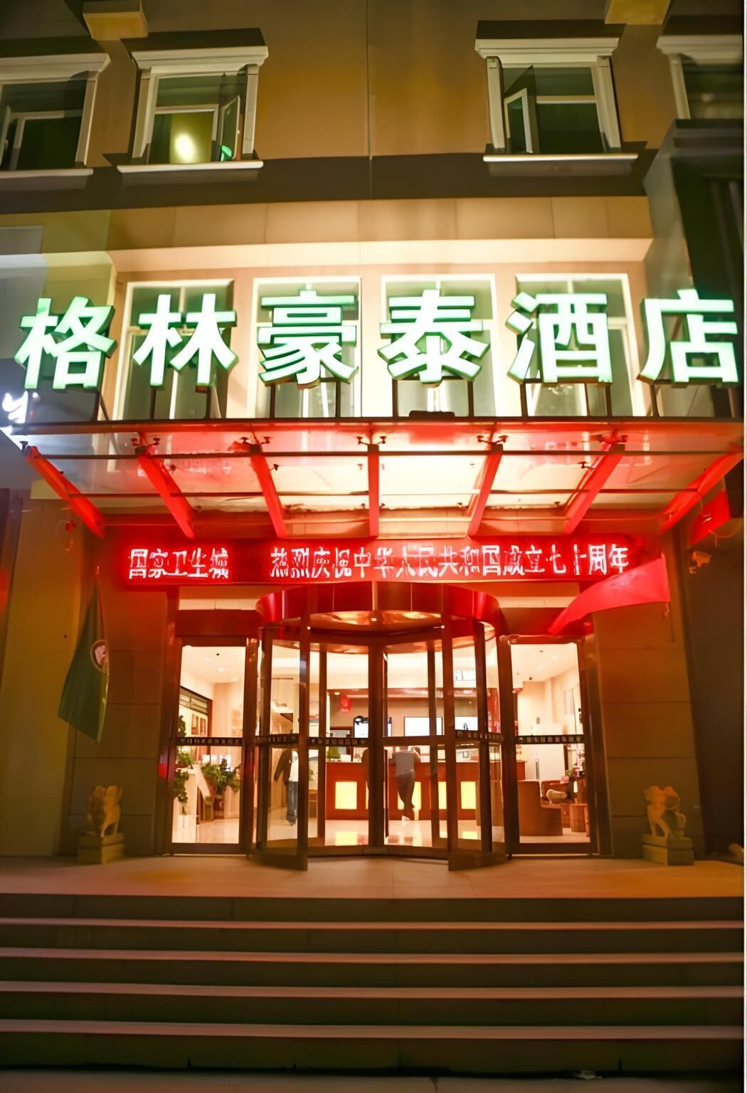 Entrada de hotel con un letrero llamativo en caracteres chinos.