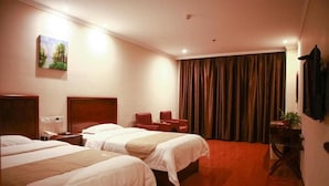 A hotel room with two beds, a desk, a chair, a telephone, a painting on the wall, and a curtain.