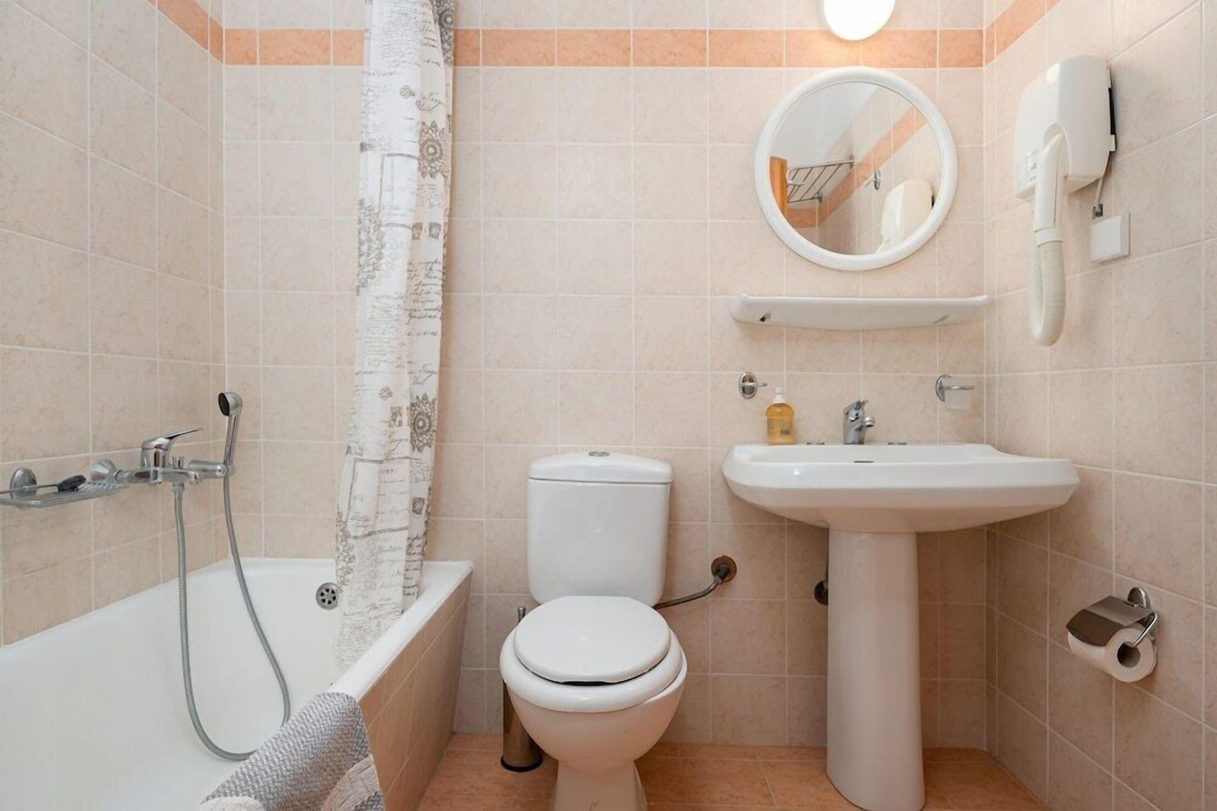 A bathroom with a bathtub, toilet, sink, and a towel rack.