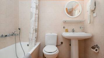 A bathroom with a bathtub, toilet, sink, and a towel rack.