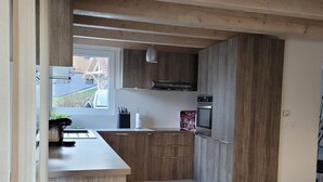 A modern kitchen with wooden cabinets, a built-in oven, and a large window. - CHARMING, COSY DUPLEX CHALET BETWEEN LAKE AND MOUNTAINS (Dingy-Saint-Clair)