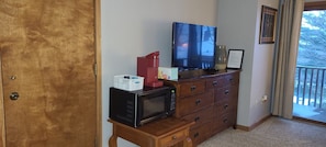 A wooden dresser with a flat-screen TV, a microwave, and a red coffee maker. - Ski, Lake. Golf - all at Shanty Creek Summit Village (Bellaire)