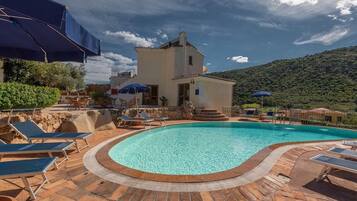 Een seizoensgebonden buitenzwembad, parasols voor strand/zwembad