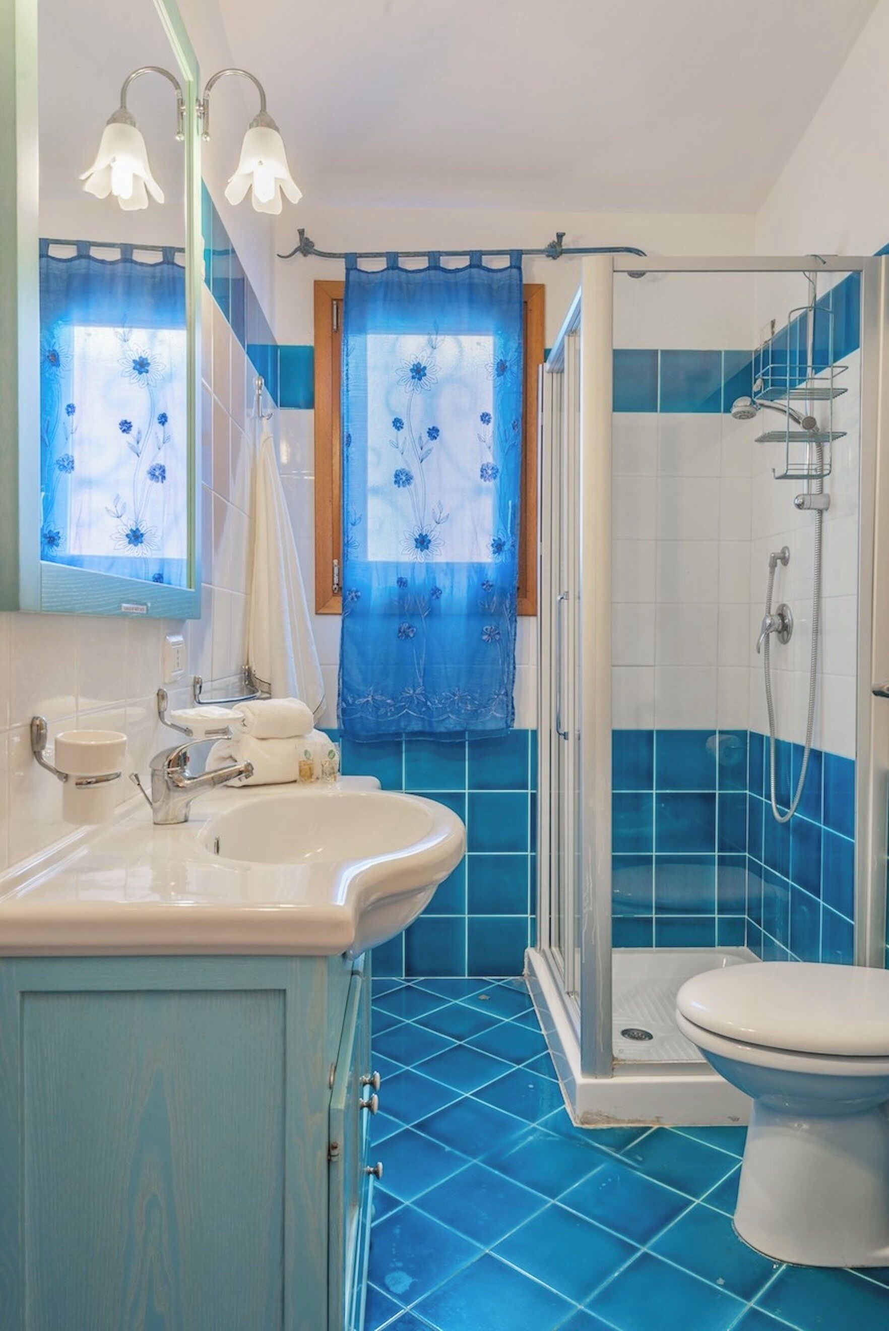 Baño con lavamanos, espejo y ducha.