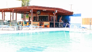 A pool area with lounge chairs and a bar. -  Family Apartment in Ayia Napa - 5 min walk to the center (Ayia Napa)