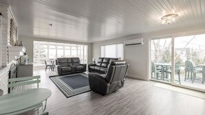 Ein geräumiges Wohnzimmer mit großem Fenster, Kamin und Essbereich.
