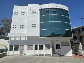 A modern building with a curved glass facade and a flat roof.