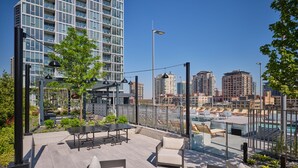 Una terraza en la azotea con asientos al aire libre, una chimenea y vistas de la ciudad.