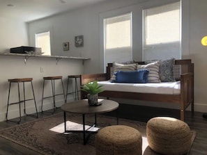 Relax in a cozy seating area with a bench and table, surrounded by a clean, minimalist design.