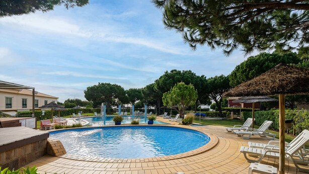 A swimming pool with lounge chairs and a gazebo. - Apartment for 4 with privileged access to the beach (Albufeira)