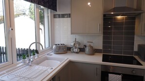 A modern kitchen with a sink, toaster, kettle, and cabinets. - Perfect Seaside Escape, Wifi Heated Indoor Pool Bar & Facilities near to St Ives (Lelant)