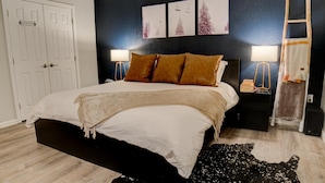 A bedroom with a bed, two bedside lamps, a dark headboard, and a white door labeled "Owner's Closet".