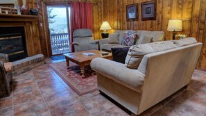 A cozy living room with a fireplace, a sofa set, a coffee table, and two lamps. - Condo three blocks from the ski area (Angel Fire)