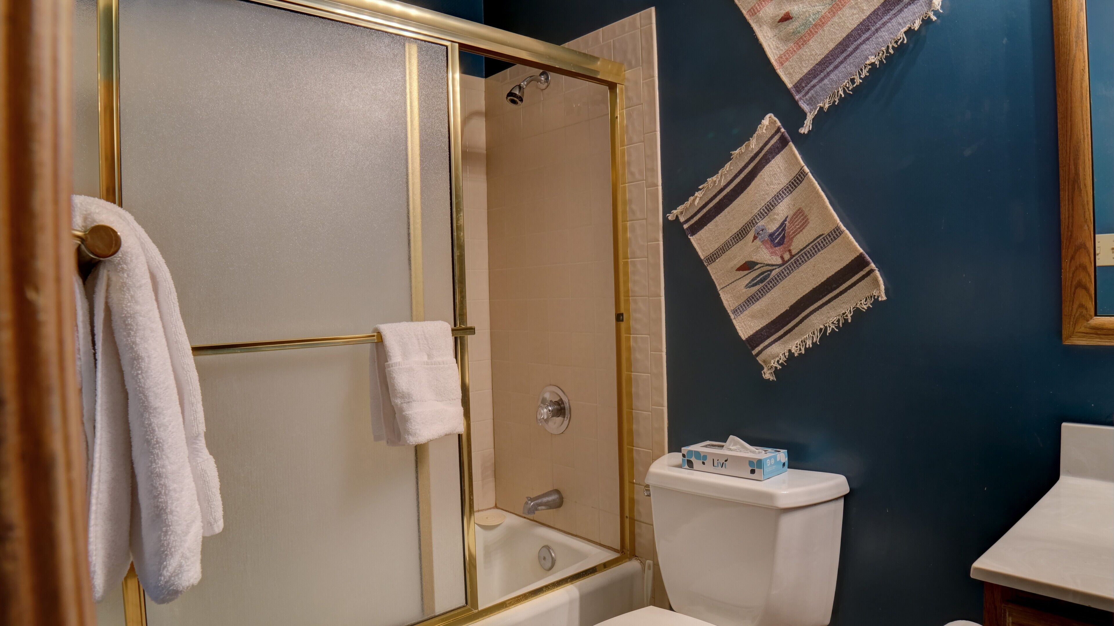 Un bagno con doccia vetrata, un water bianco e un lavandino.