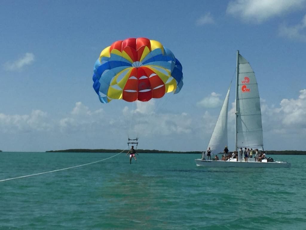 A sailboat with a parasail in the background.