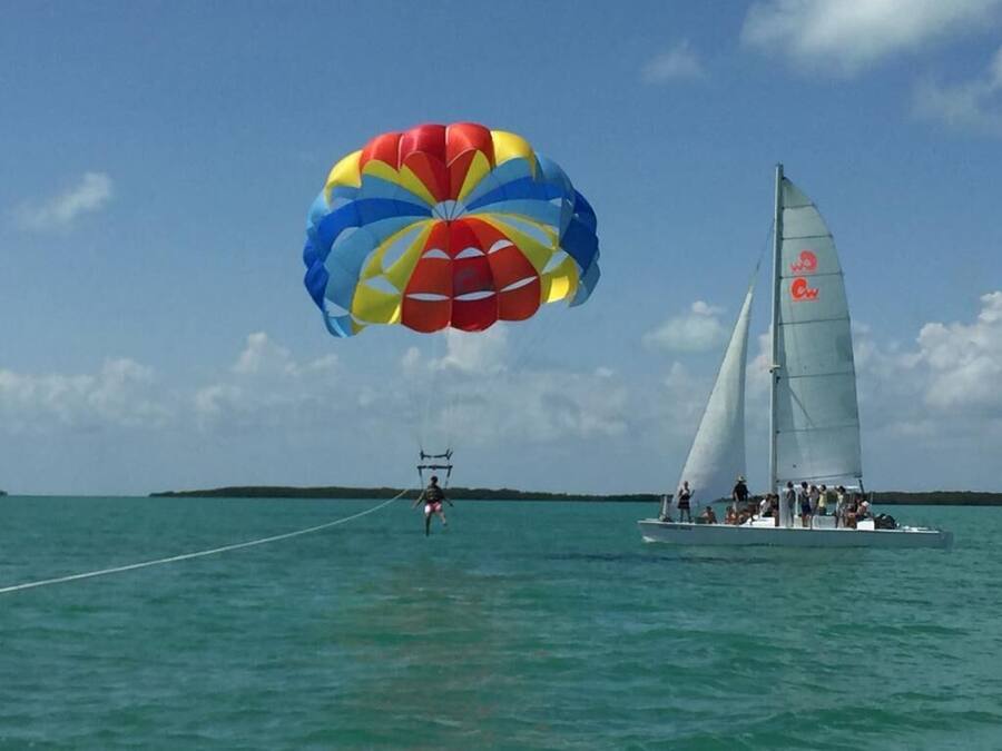 A sailboat with a parasail in the background.