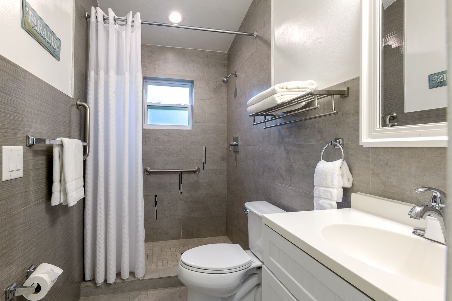 Une salle de bain moderne équipée d’une douche, de toilettes et d’un lavabo.