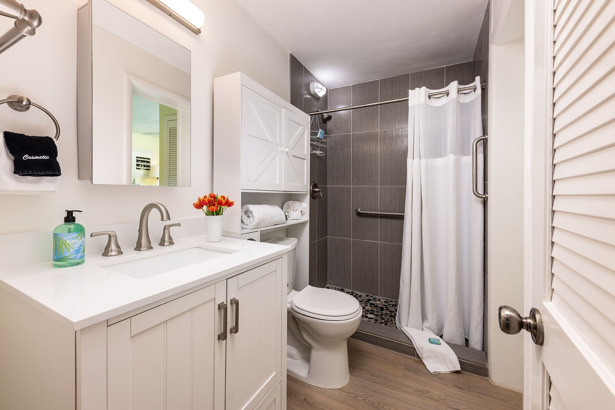 A modern bathroom with a white sink, a toilet, and a shower area.