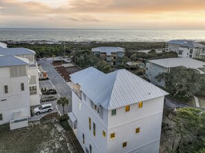 A coastal residential area with multiple two-story buildings, some with visible balconies and a paved driveway.
