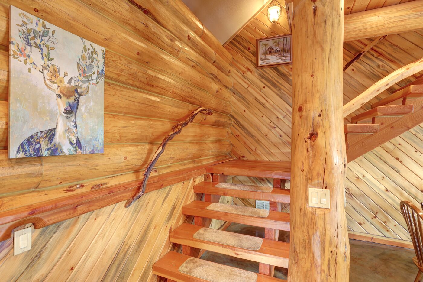 Ein Holzinnenraum mit Treppe, Holzwänden und einem Bild von einem Reh.