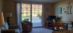 Ein Wohnzimmer mit Sofa, Sesseln, Fernseher und Esstisch.