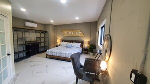 Une chambre à coucher comprenant un lit, des tables de chevet, une chaise, un bureau, un miroir et une étagère fixée au mur.