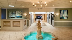 Una hall con fontana centrale, reception e opere d'arte alle pareti.