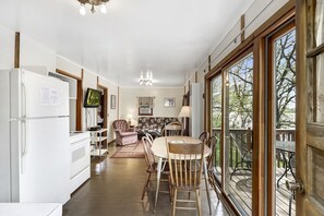 A modern kitchen with a dining area, large windows, and a view of the outdoors. - Swan Lake Resort & Campground - Lakeside Cabin #1 (Fergus Falls)