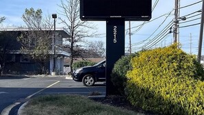 Une enseigne pour l’hôtel Avon, avec un écran numérique affichant le numéro 2215.