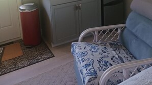 A compact kitchen with a microwave, toaster, and coffee machine. There is a trash bin and a framed picture above the counter. - A private waterfront Lake Ida setting located in the middle of 23 acres (Boynton Beach)