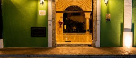 La entrada de Real Hispano Valladolid, con fachada verde, un arco de bienvenida y dos lámparas fijadas a la pared.