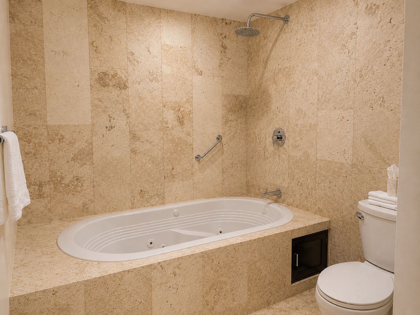 Un baño con una bañera independiente, un cabezal de ducha, un inodoro y un perchero para toallas.