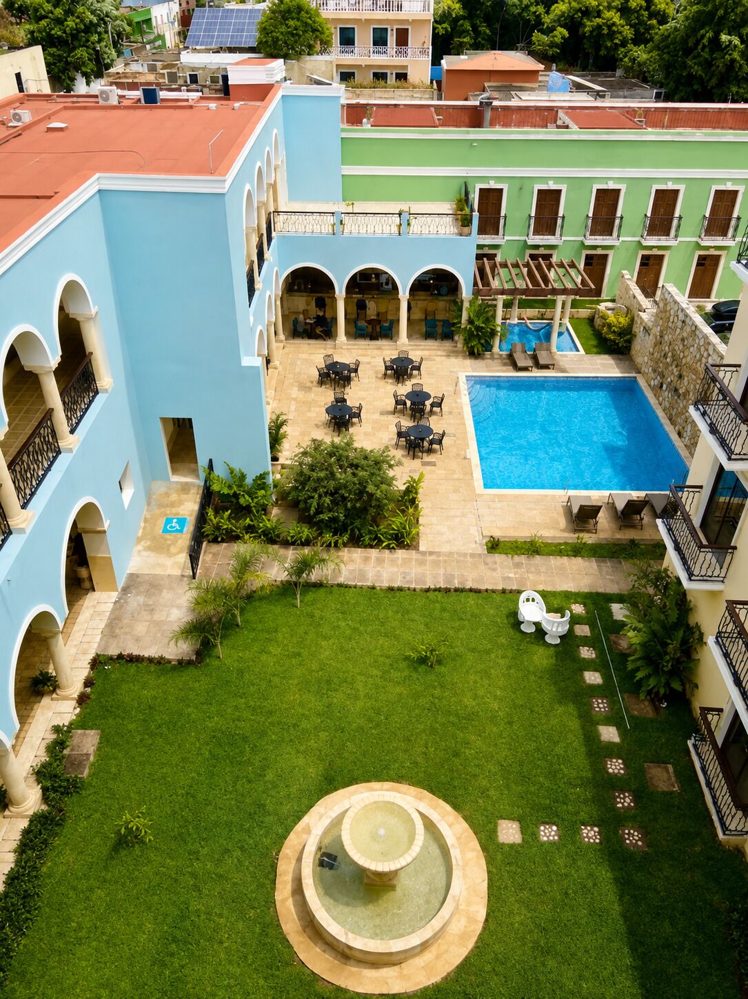 A courtyard with a swimming pool, outdoor seating, and a fountain.