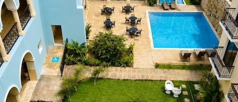 A courtyard with a swimming pool, outdoor seating, and a fountain.