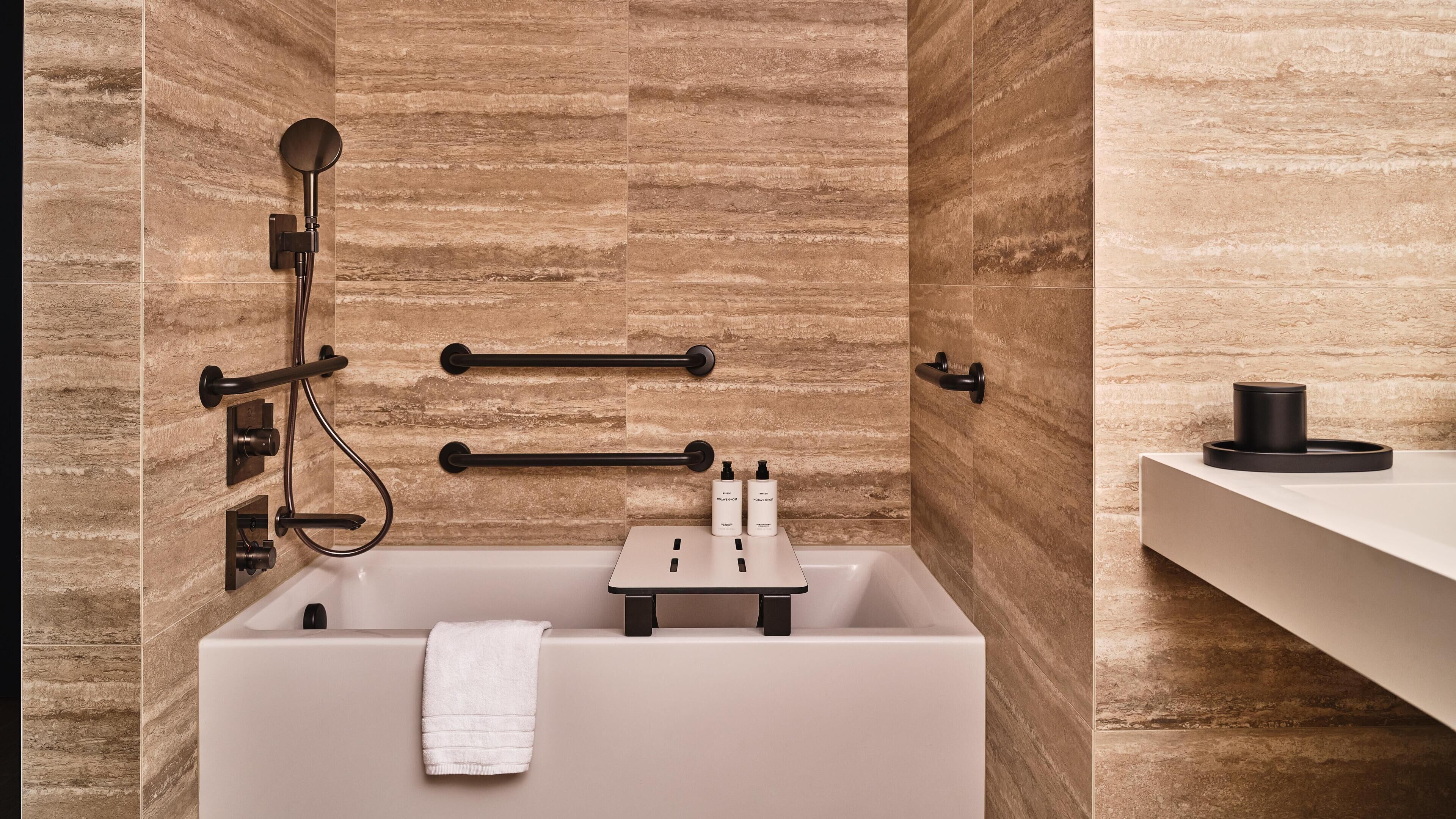 Une salle de bain moderne équipée d’une baignoire, d’un porte-serviettes et de commandes pour la douche.